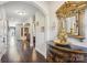 Elegant hallway with arched doorways, dark hardwood floors, ornate mirror, and stylish console table at 21610 Rio Oro Dr, Cornelius, NC 28031
