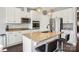 Modern kitchen featuring an island with seating, granite countertops, and stainless steel appliances at 21610 Rio Oro Dr, Cornelius, NC 28031
