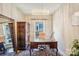 Home office features a modern chandelier, an antique cabinet, and a glass-topped wooden desk at 21610 Rio Oro Dr, Cornelius, NC 28031