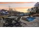 Backyard patio with wrought iron dining table, lounge chairs, and plunge pool overlooking serene waterfront and boat docks at 21610 Rio Oro Dr, Cornelius, NC 28031