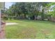 Lush green backyard featuring mature trees, a concrete patio, and a charming blue storage shed at 2632 Montford Nw Ave, Concord, NC 28027