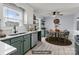 Staged eat-in kitchen area with green cabinetry, stainless steel appliances, and light wood flooring at 2632 Montford Nw Ave, Concord, NC 28027