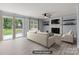 Staged living room featuring a white brick fireplace, large windows, and sliding door access to a deck at 2632 Montford Nw Ave, Concord, NC 28027