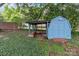 Charming blue storage shed with a sheltered area, surrounded by lush greenery at 2632 Montford Nw Ave, Concord, NC 28027
