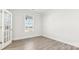 Bright, sunlit room with wood floors, large window, and French doors, creating an inviting space at 279 Miramar Dr, York, SC 29745