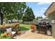 Outdoor patio area with grill, seating, string lights, and a well-manicured lawn at 303 N Main N St, Granite Quarry, NC 28146
