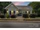 Charming home featuring a well-manicured lawn, stone retaining wall, and inviting front porch with dark shutters at 303 N Main N St, Granite Quarry, NC 28146