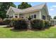 Charming home featuring a well-manicured lawn, lush landscaping and dark shutters at 303 N Main N St, Granite Quarry, NC 28146