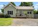 Charming single-Gathering home featuring a metal roof, black shutters, and a cozy front porch at 303 N Main N St, Granite Quarry, NC 28146