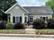 Charming home featuring a stone entryway, manicured shrubs, and decorative black shutters at 303 N Main N St, Granite Quarry, NC 28146