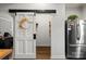 Kitchen pantry with sliding barn door and stainless steel fridge at 303 N Main N St, Granite Quarry, NC 28146