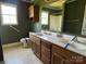 Bathroom featuring a double vanity, a large mirror, and a walk in shower with olive walls at 3240 St Vincent Dr, Claremont, NC 28610