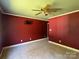 Bedroom featuring crimson walls, and base molding, with carpeted flooring and an adjacent room at 3240 St Vincent Dr, Claremont, NC 28610