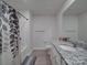 Well-lit bathroom featuring a granite countertop, white cabinets, and a shower with a patterned curtain at 3322 Brighton Dr, Gastonia, NC 28052