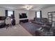 Comfortable living room with large tv, ceiling fan, plush carpet, and a gaming desk at 3322 Brighton Dr, Gastonia, NC 28052