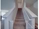 Carpeted stairway leading to the second floor landing with white railing at 3322 Brighton Dr, Gastonia, NC 28052