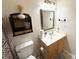 Bathroom showcasing a vanity with a wood-grain cabinet, framed mirror, and extra shelving for storage at 3602 Melrose Cottage Dr, Matthews, NC 28105