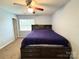 Bedroom featuring a ceiling fan, window with blinds, and a bed with built-in storage and headboard at 3602 Melrose Cottage Dr, Matthews, NC 28105