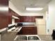 Functional kitchen with dark wood cabinets, a dual-basin sink, and essential appliances at 3602 Melrose Cottage Dr, Matthews, NC 28105