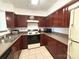 Efficient kitchen with dark wood cabinets, a range, and necessary appliances at 3602 Melrose Cottage Dr, Matthews, NC 28105