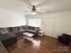Well-lit living room features a sectional sofa, modern coffee table, hardwood floors, and ample natural light at 3602 Melrose Cottage Dr, Matthews, NC 28105