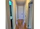 Well-lit hallway featuring hardwood floors and multiple doors leading to different rooms at 401 Pamela St, Gastonia, NC 28054
