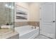 Bright bathroom features bathtub with tile surround, shower with glass, and white door at 4028 Woodsmill Rd, Fort Mill, SC 29707