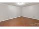 A cozy bedroom with gleaming hardwood floors, fresh paint, and a modern recessed light fixture at 4028 Woodsmill Rd, Fort Mill, SC 29707