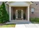 Inviting front porch with brick columns, dark green door, and manicured greenery at 4028 Woodsmill Rd, Fort Mill, SC 29707