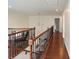 Hallway with hardwood floors, wood and metal railing, and an overhead light fixture at 4028 Woodsmill Rd, Fort Mill, SC 29707