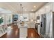 Modern kitchen with white cabinets, granite countertops, and stainless steel appliances overlooking the living room at 4028 Woodsmill Rd, Fort Mill, SC 29707