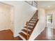 Classic staircase with wood steps, black wrought iron railing, and white trim at 4028 Woodsmill Rd, Fort Mill, SC 29707