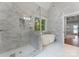 Elegant bathroom features a glass shower, luxurious soaking tub, and marble tile at 434 Breezewood Dr, Belmont, NC 28012