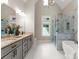 Bright bathroom boasts double vanity, marble shower, soaking tub and modern fixtures at 434 Breezewood Dr, Belmont, NC 28012