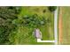 An aerial view showcases the home's position between a lush forest and open field, next to a road at 4470 W Bandys Cross Rd, Claremont, NC 28610
