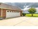 Garage and driveway featuring a white door, next to a grassy lawn and some plants at 4470 W Bandys Cross Rd, Claremont, NC 28610