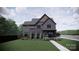 Rendering of a two-story home with gray siding, brick accents, and manicured landscaping at 4900 Doris Ave, Charlotte, NC 28205