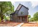 New two-story home featuring gray siding, brick accents, covered porch, and professional landscaping at 4900 Doris Ave, Charlotte, NC 28205