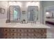 Bathroom featuring double sinks, a vanity, and mirrors, with a view of the walk-in shower at 5900 Colwick Nw Ct, Concord, NC 28027