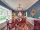 Elegant dining room featuring blue walls, white trim, a large window, and a traditional chandelier at 5900 Colwick Nw Ct, Concord, NC 28027