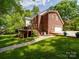 Rear exterior view of the home, featuring a deck, attached garage, and lush green lawn at 5900 Colwick Nw Ct, Concord, NC 28027