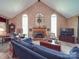 Cozy living room with vaulted ceilings, a brick fireplace, and large windows offering natural light at 5900 Colwick Nw Ct, Concord, NC 28027