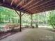 Covered brick patio with a hammock, plants, and garden, offering a relaxing outdoor space at 5900 Colwick Nw Ct, Concord, NC 28027