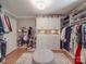 Spacious walk-in closet with custom shelving, ample storage, and a center ottoman at 5900 Colwick Nw Ct, Concord, NC 28027
