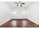 A spacious bedroom is bright with gleaming hardwood floors and a ceiling fan at 6033 Bountiful St # 201, Belmont, NC 28012