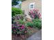 Lush garden featuring vibrant purple azaleas, red roses, and a charming statue, creating a picturesque landscape at 6033 Bountiful St # 201, Belmont, NC 28012