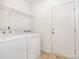 Laundry room with white washer and dryer features tile floor and storage shelves for convenience at 6033 Bountiful St # 201, Belmont, NC 28012
