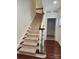 Carpeted staircase with stained handrail and white spindles and wood floors leads to the upper level at 6033 Bountiful St # 201, Belmont, NC 28012