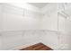 Walk-in closet with custom white shelving offers ample storage space, and beautiful wood flooring at 6033 Bountiful St # 201, Belmont, NC 28012