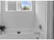 Relaxing bathtub area with a soaking tub and small window for natural light at 7604 Tanglewood Way, Denver, NC 28037